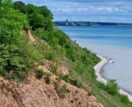 Web banner for Cedar Gorge Clay Bluffs fundraising with a photo of a bluff on Lake Michigan.
