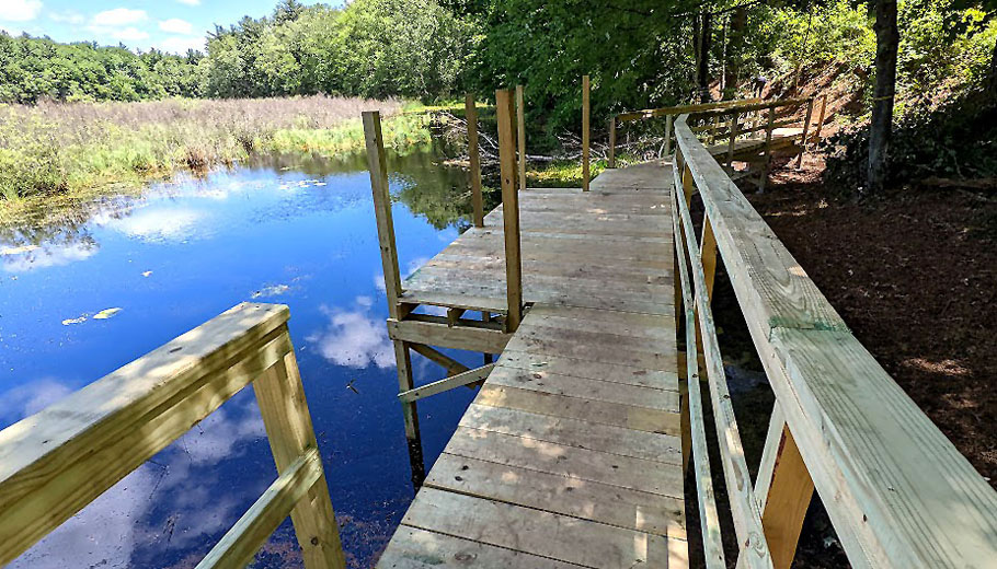 Wooden boardwalk that opens into a body of water