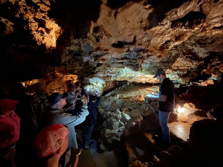 People exploring a cave and taking photos.