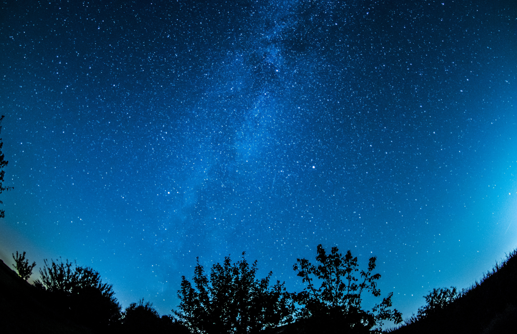 A blue sky at night full of stars.