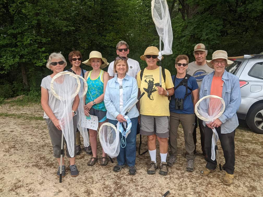 Individuals pose for a group photo while holding butterfly nets.