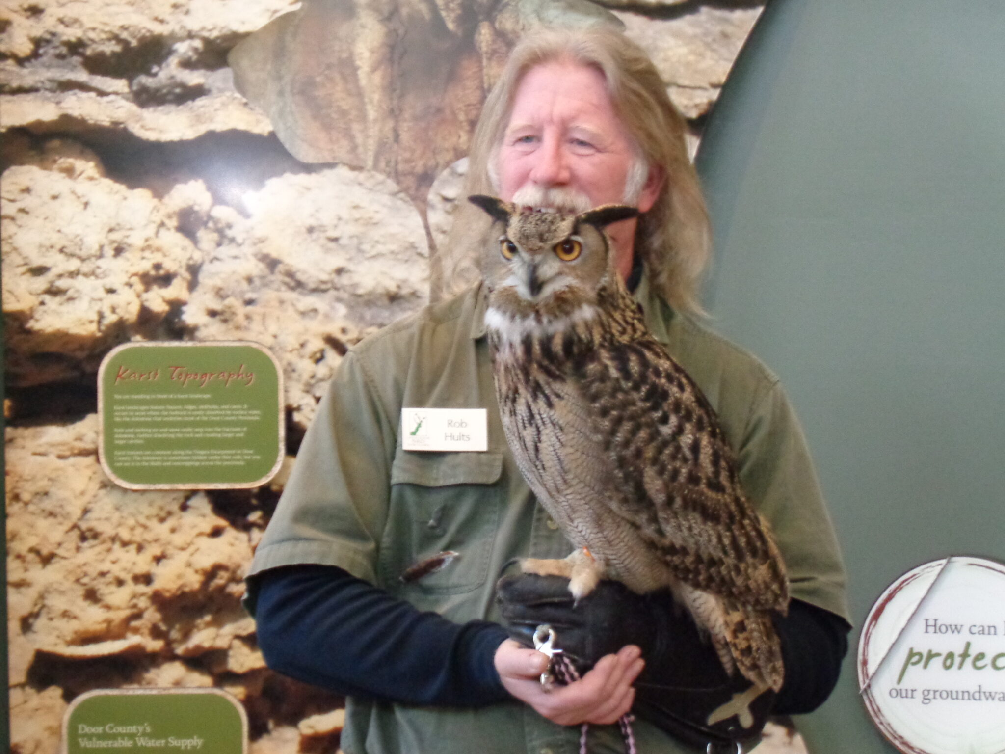 A bird handler holding a large owl.